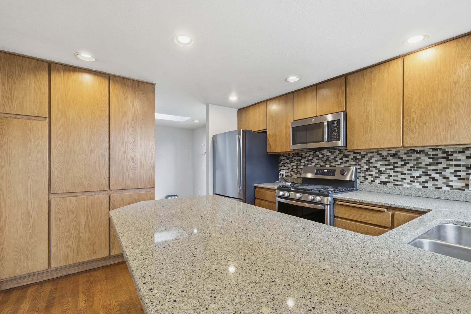 Renovated kitchen with slab granite countertops and stainless appliances