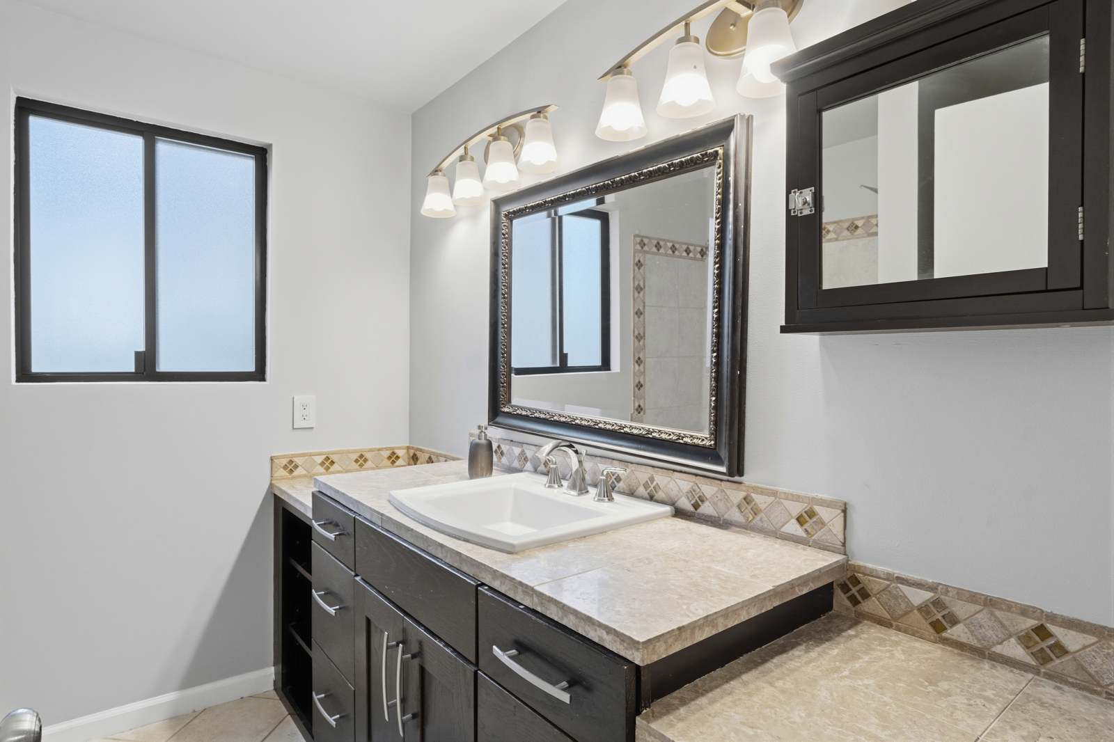 Bathroom with tile detail and vanity at Kamilche Shores